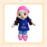 A plush toy depicting a Sikh girl with a pink headscarf, wearing a blue t-shirt and jeans, and carrying a pink bag.